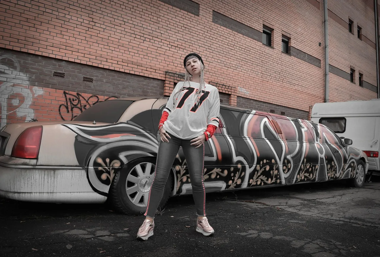 Urban artist in front of a graffiti-covered limousine Urban artist in front of a graffiti-covered limousine