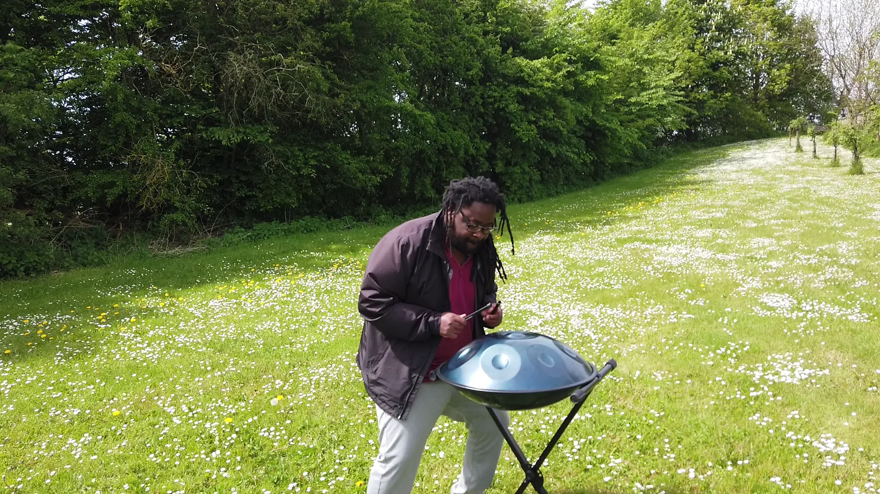 Musician playing a handpan outdoors Musician playing a handpan outdoors
