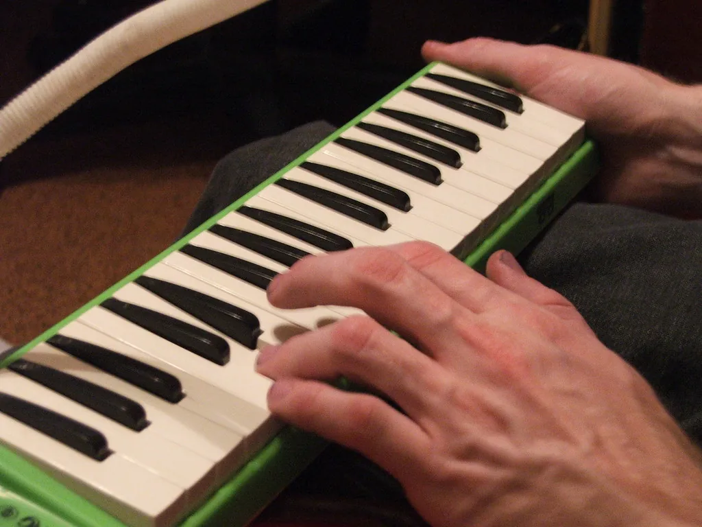 Musician playing a green melodica Musician playing a green melodica