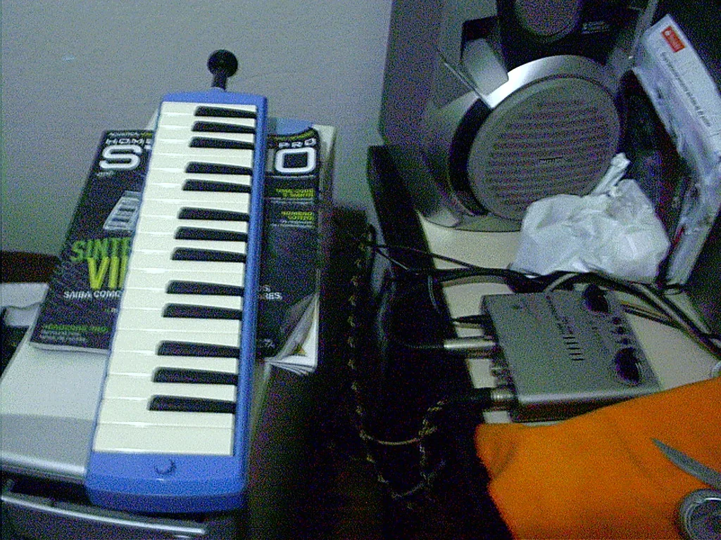 Blue melodica resting on a keyboard