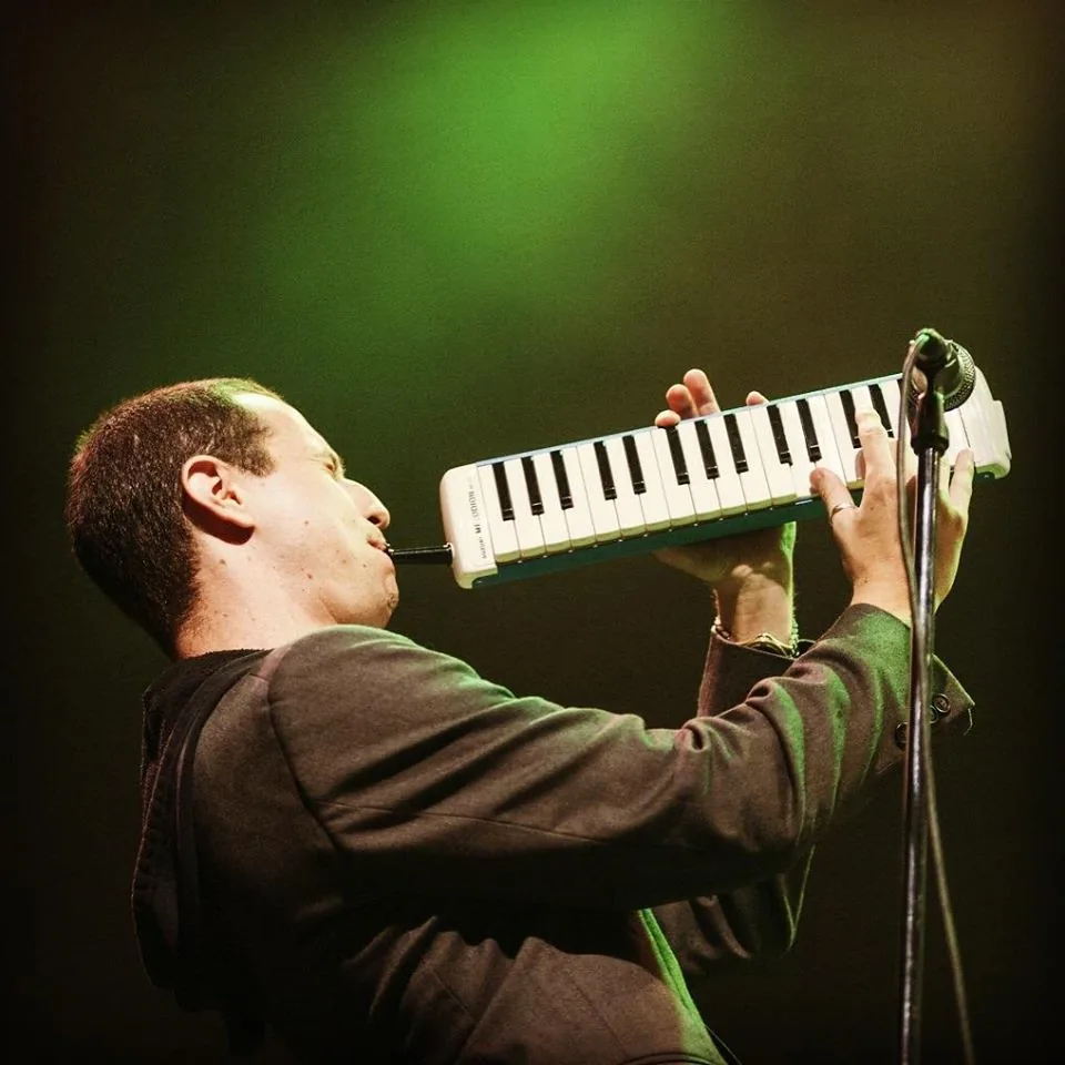 Musician playing a melodica on stage Musician playing a melodica on stage